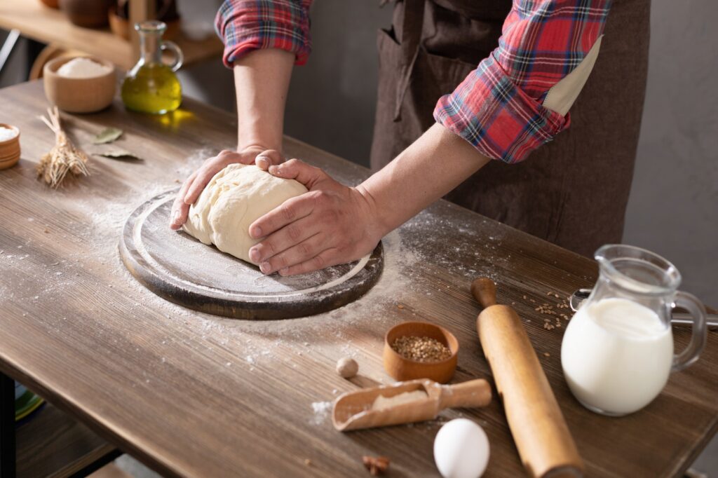baker-man-making-dough-and-bakery-ingredients-for-homemade-bread-cooking-on-table-bakery-concept.jpg